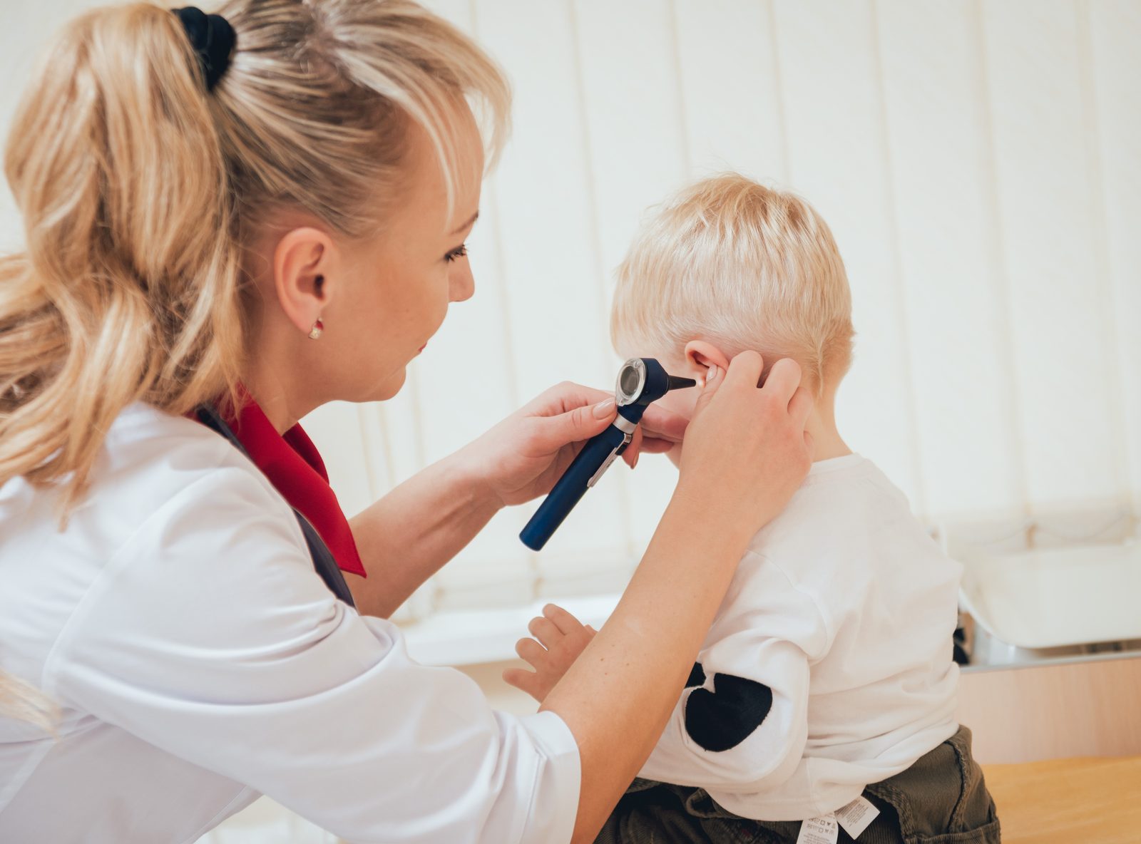 Pediatric ENT specialist examining a child